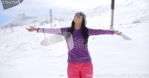 Image of Happy young woman embracing the winter sun