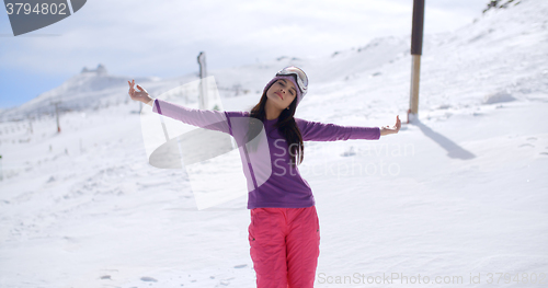 Image of Happy young woman embracing the winter sun