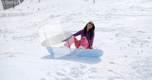 Image of Laughing snowboarder falls in the snow