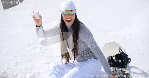 Image of Playful young woman throwing a snowball