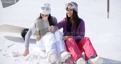 Image of Two young women sitting waiting in the snow