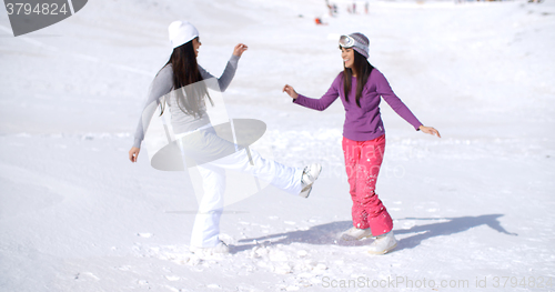 Image of Two young woman frolicking in winter snow