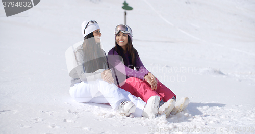 Image of Two Friends Sitting Together on Sunny Ski Hill