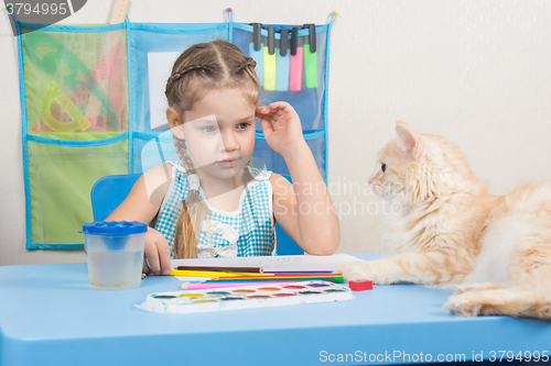 Image of  Five-year girl drawing pencils looked at the cat