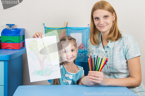Image of Five-year girl shows a drawing which she painted with her mother