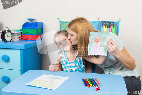 Image of Mum kisses the daughter because she drew her beautiful