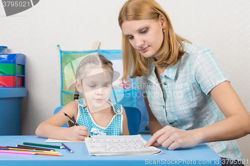 Image of Mentor shows five children to write letters correctly