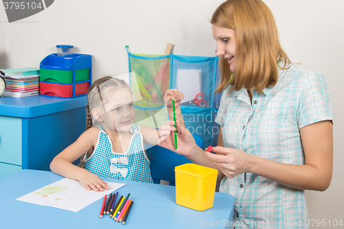 Image of The five-year child put a finger on the tip of a pencil mom