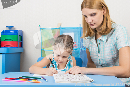 Image of Tutor helps the child to spell the alphabet