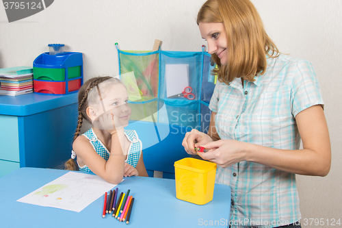 Image of The five-year child and mother that sharpens pencils looked at each other