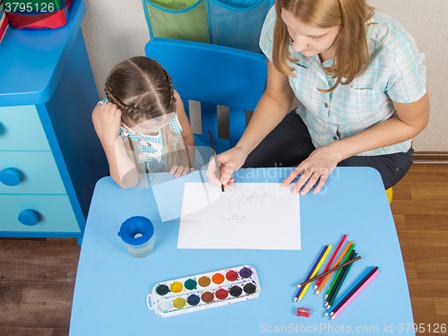 Image of Mentor and five year old girl at the table draw a picture in kindergarten