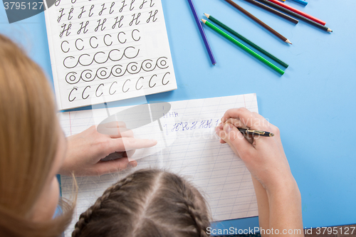 Image of My mother helps the child to spell the letters of the alphabet, a top view