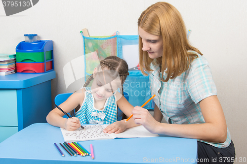 Image of The young girl engaged in a five year old girl spelling