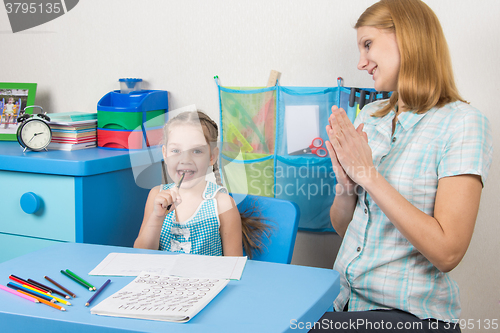 Image of Five-year girl and a tutor is fun sitting at the table and enjoy