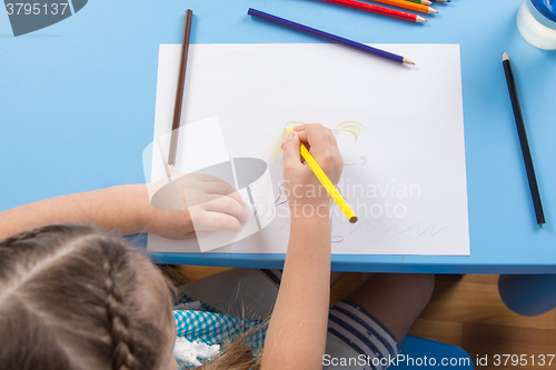 Image of Five-year girl draws pencil on paper, top view