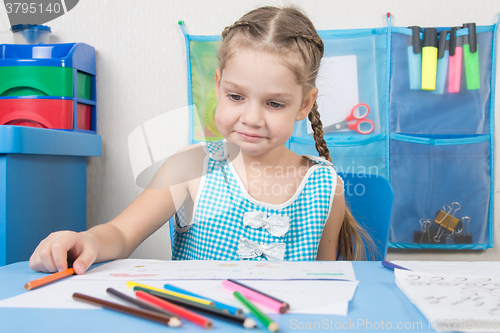 Image of Upset girl draws with crayons