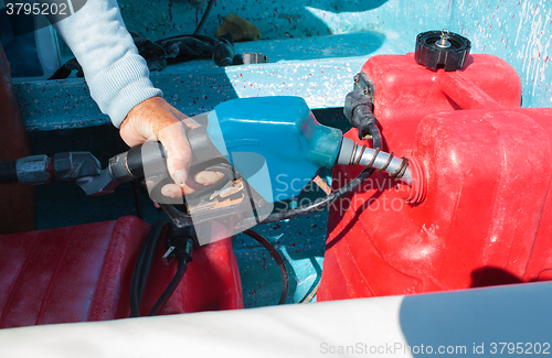 Image of Man fueling tank of a motor boat before travel