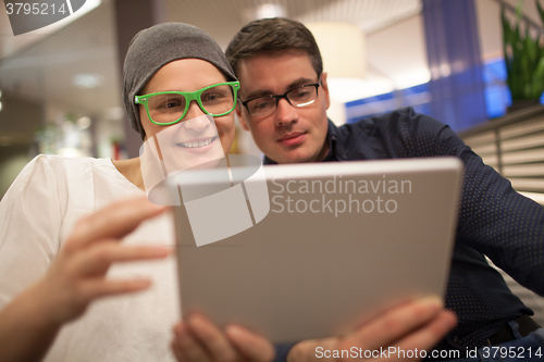 Image of Man and woman using electronic tablet in the restaurant