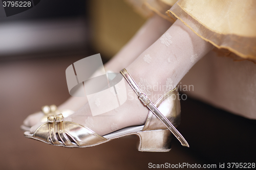 Image of Girl wearing elegant gold sandals