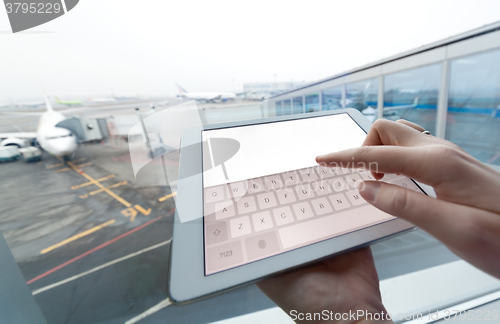 Image of Woman with tablet computer empty screen at airport