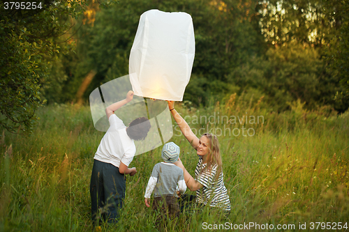 Image of Mother with her sons flying paper lantern