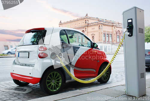 Image of Electro car is charging on the street.