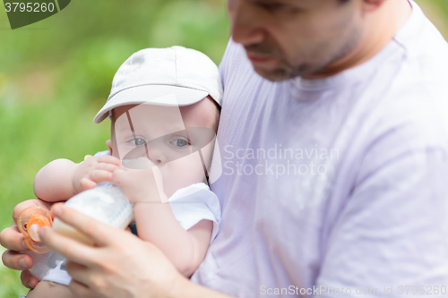 Image of Father feeding his baby from the bottle