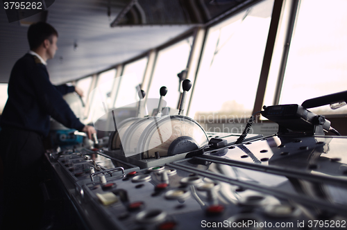 Image of Navigation officer driving ship on the river.