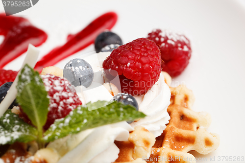 Image of Waffle and cream topped with fresh berries