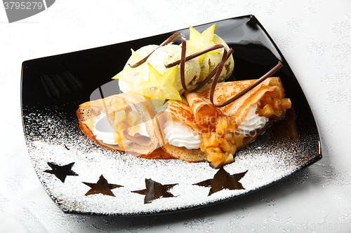 Image of Golden pancakes with carambola and cream