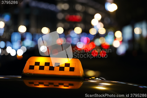 Image of Illuminated taxi cab sign on a city street