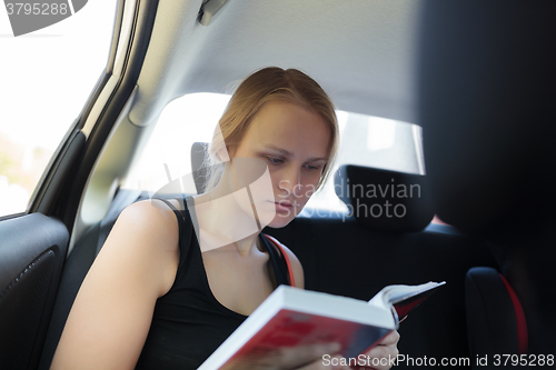 Image of Woman reading a book in the car