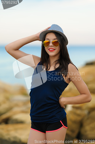 Image of Young smiling girl in grey hat and sun glasses