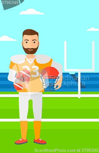 Image of Rugby player with ball and helmet in hands.