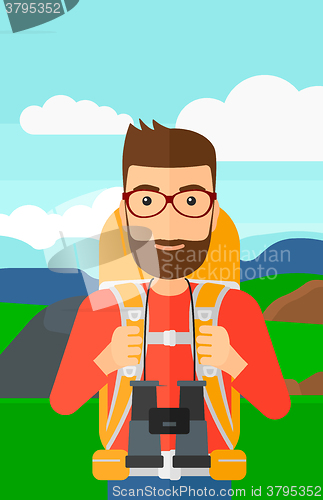 Image of Cheerful backpacker with binoculars.