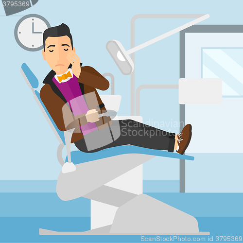 Image of Man suffering in dental chair.