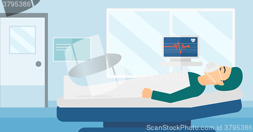 Image of Patient lying in hospital bed with heart monitor.