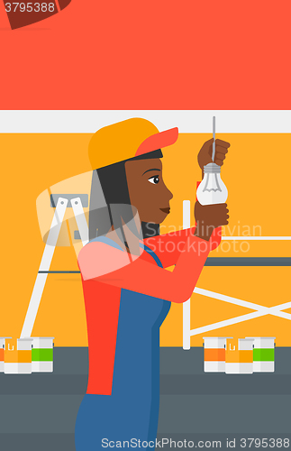 Image of Electrician twisting light bulb.
