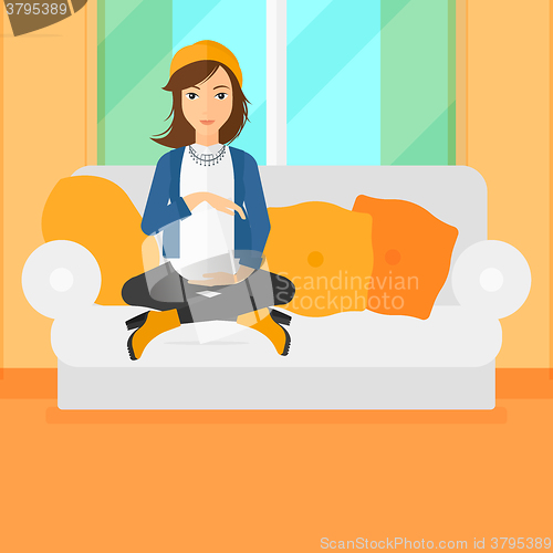 Image of Pregnant woman sitting on sofa.