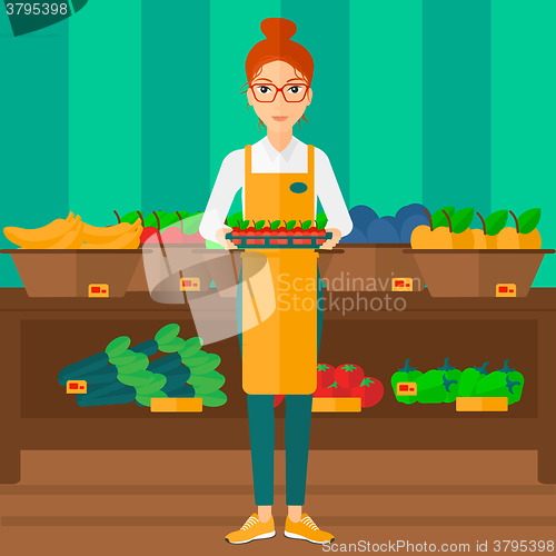 Image of Supermarket worker with box full of apples.
