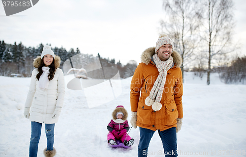 Image of happy family with sled walking in winter outdoors