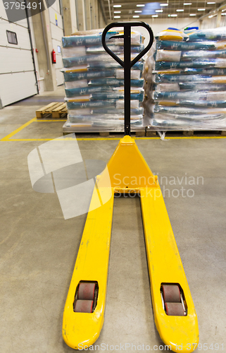 Image of manual loader and cargo piles at warehouse