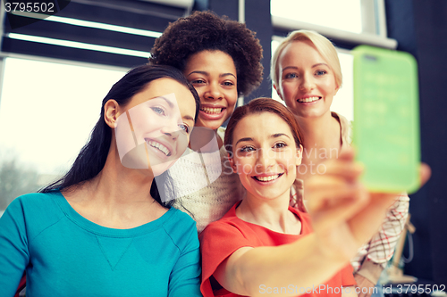 Image of happy young women taking selfie with smartphone