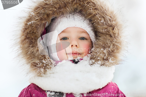 Image of face of happy little kid or girl in winter clothes