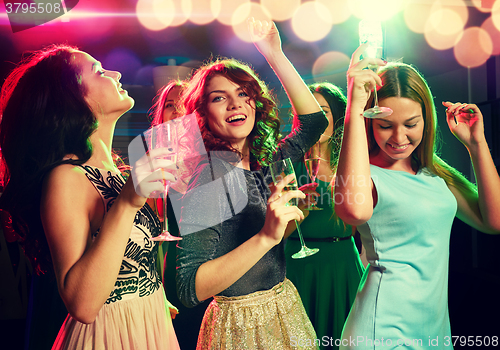 Image of smiling friends with glasses of champagne in club