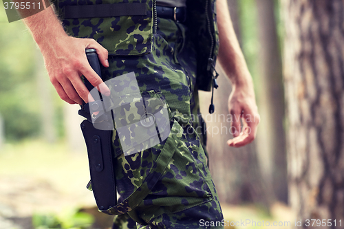 Image of close up of soldier or hunter with knife in forest