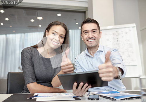 Image of smiling businesspeople with tablet pc in office