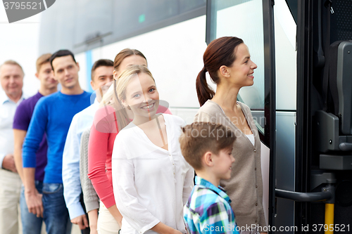 Image of group of happy passengers boarding travel bus