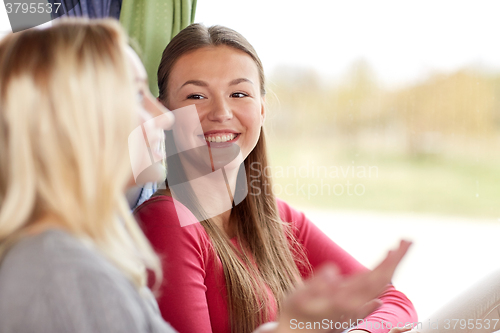 Image of happy young women talking in travel bus or train