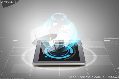 Image of close up of tablet pc with earth globe hologram